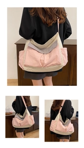 Detail view of large canvas messenger bag showing patchwork design and side pocket