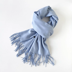 Detailed view of light blue scarf showing soft blended texture and dense fringe edges