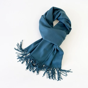 Macro detail of the deep teal pashmina scarf fabric and matching fringe tassels