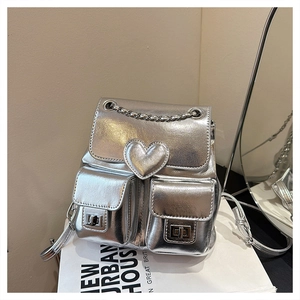 Detailed macro view of silver mirror PU leather backpack with heart patch and chain handle