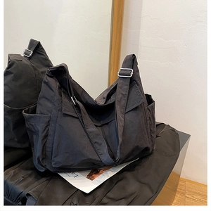Detail view of large black canvas crossbody bag with water-resistant nylon texture