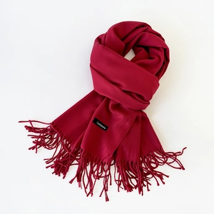 Detailed close-up of dark red cashmere scarf featuring soft texture and tassel edges