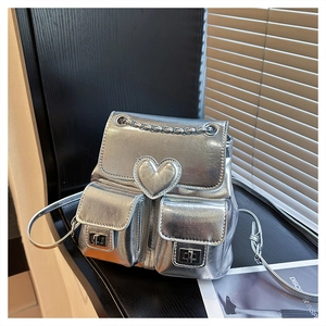 Close-up of metallic silver backpack with heart design and small buckled pockets