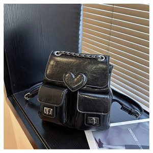 Detail of black mini backpack with heart decor and silver twist-lock pockets