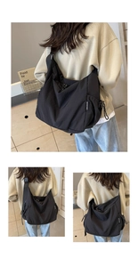 Detail view of large black nylon crossbody bag with wide adjustable strap and side pocket