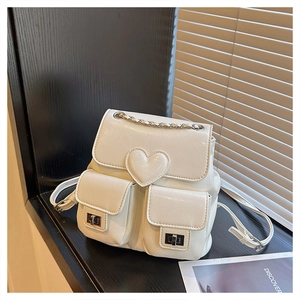 Close-up of white leather mini backpack with 3D heart detail and silver metal twist locks