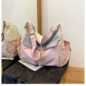 Detailed close-up of a pink and beige canvas crossbody bag with large front flap pocket