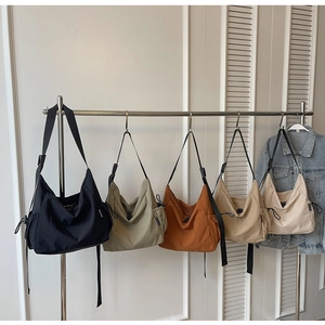 Detail view of large canvas crossbody bags in five colors with adjustable drawstring side