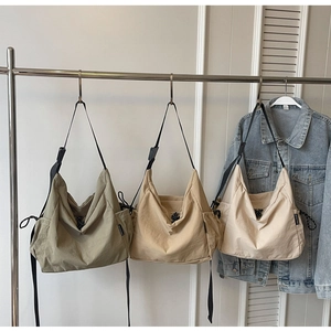 Detail of canvas tote bags with drawstring side pockets and adjustable black straps