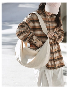 Minimalist beige oversized nylon shoulder bag in a lifestyle outdoor street setting