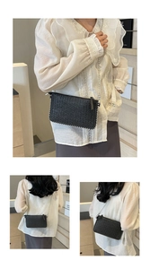 Detail of black woven crossbody bag with silver bead trim and metal chain strap
