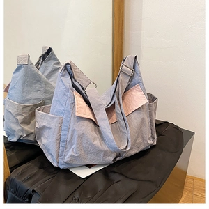 Detail view of large canvas crossbody bag in blue and pink with adjustable strap