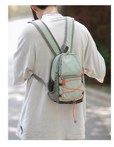 Mini zaino outdoor verde menta e grigio indossato da una persona per mostrare le misure