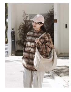 Close-up of beige nylon shoulder bag showing durable texture and large capacity design