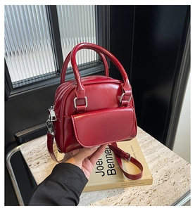 Detail of red patent leather bridal handbag with silver hardware and detachable strap