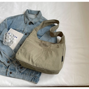 Olive green nylon hobo bag featuring wide shoulder strap and functional front pockets