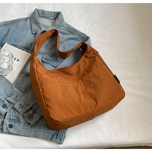 Detailed shot of a brown nylon tote bag with visible stitching and branded side label