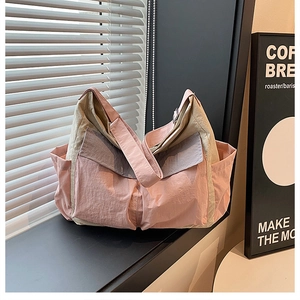 Detail view of the tricolor canvas tote bag showing side pocket and wide shoulder strap