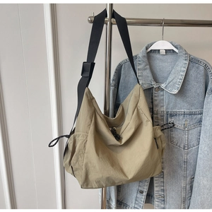 Detail view of khaki large capacity nylon tote bag with side drawstring and black strap