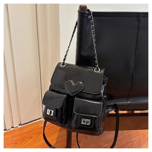 Detailed view of black glossy bucket backpack featuring heart appliqué and silver twist locks