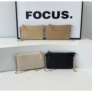 Detailed group view of rectangular straw woven mini bags with metallic bead trim and chain straps