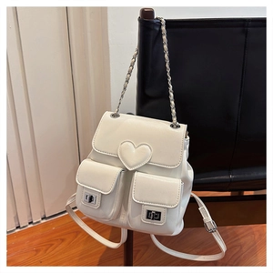White leather mini backpack featuring embossed heart detail and silver metal twist locks