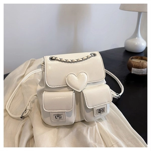Detail of white PU leather backpack with heart motif and metal chain handle