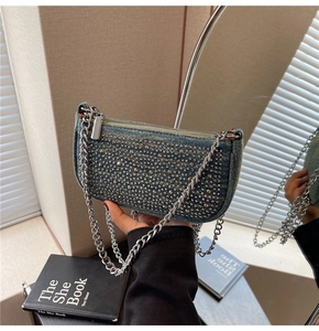 Detail of denim shoulder bag with rhinestone rows and silver metal chain strap