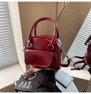 Detail of glossy deep red wedding handbag with polished silver hardware and top handle