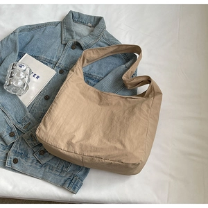 Detail shot of the khaki nylon hobo bag textured material on a clean white background