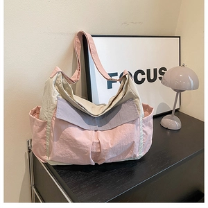 Detail of color-block nylon tote bag with functional pockets and adjustable shoulder strap