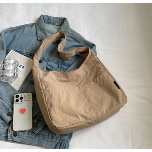 Detail view of khaki large capacity tote bag with dual front pockets and canvas texture