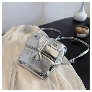 Macro shot of silver bucket bag with 3D heart detail and chain on textured cloth