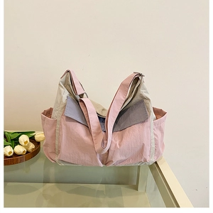 Detail of multi-pocket canvas messenger bag showing pink and beige contrast panels