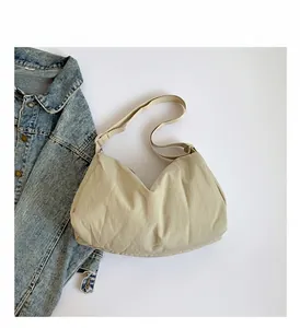 Detailweergave van beige halve maantas met geplooide nylon textuur en verstelbare riem