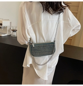 Detail of blue denim crossbody bag with sparkling rhinestones and silver chain strap