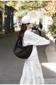 Outdoor shot of a large black nylon hobo bag showing casual style and slouchy texture