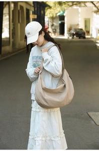 Detail of minimalist beige nylon crescent tote bag with wide strap for daily commute