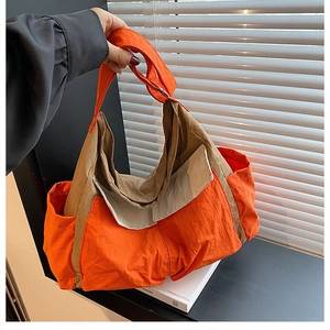 Detail view of large orange and khaki canvas messenger bag with side pocket and side strap