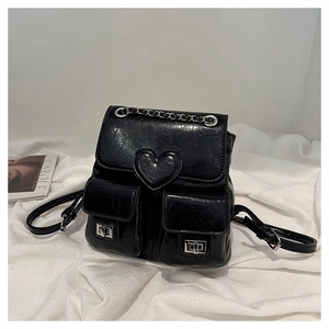 Detail of black glossy bucket backpack with silver heart buckle and chain handle