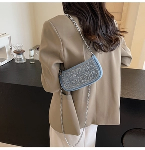 Detail of blue denim mini bag with silver rhinestones and delicate metal chain strap
