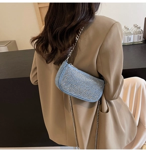 Detail of light blue crossbody bag with glittering rhinestones and silver chain strap