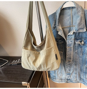Detail of minimalist nylon shoulder bag with exterior pocket and textured fabric finish