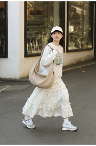 Outdoor street style shot of a beige large capacity nylon shoulder bag for casual wear