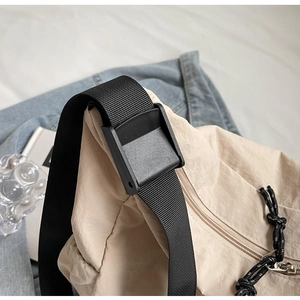 Detail of beige canvas bag strap with adjustable buckle and drawstring zip closure