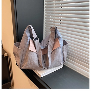 Detail of grey-blue nylon crossbody bag showing the adjustable strap and metal buckle