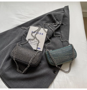 Detailed shot of denim shoulder bags with silver rhinestones and metal chain straps