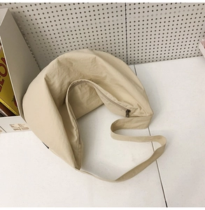 Top view of beige nylon crescent bag featuring wide strap and metal zipper closure
