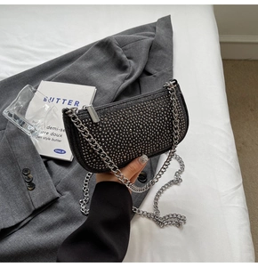 Close-up of black crossbody bag with silver rhinestones and chunky metal chain strap