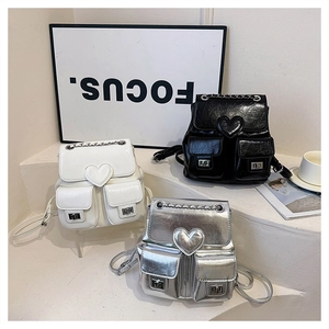 Detailed display of mini bucket backpacks in black, white, and silver with heart-shaped flaps